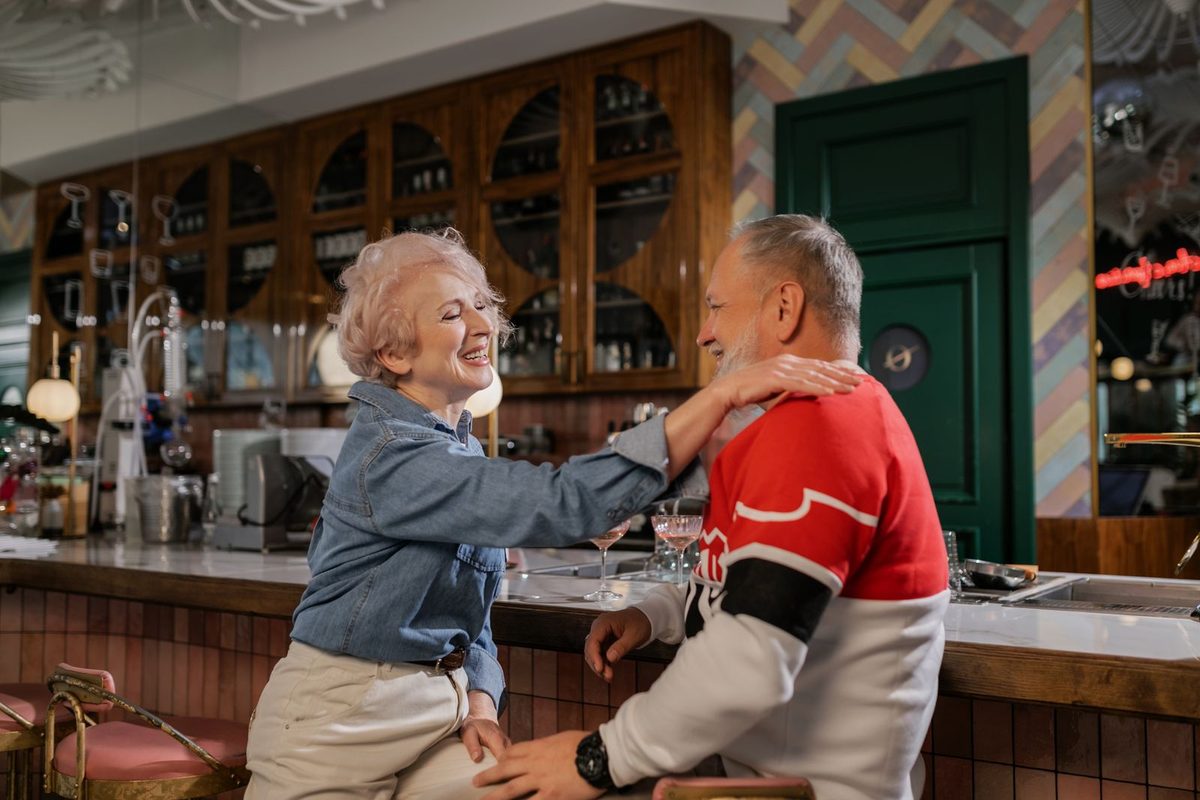 Älteres Paar lacht gemeinsam in einem Café