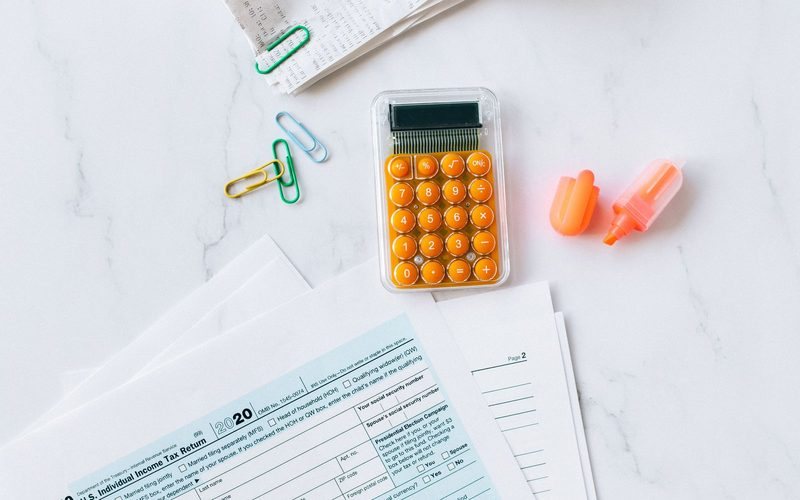 Taschenrechner und Steuerformulare auf dem Schreibtisch