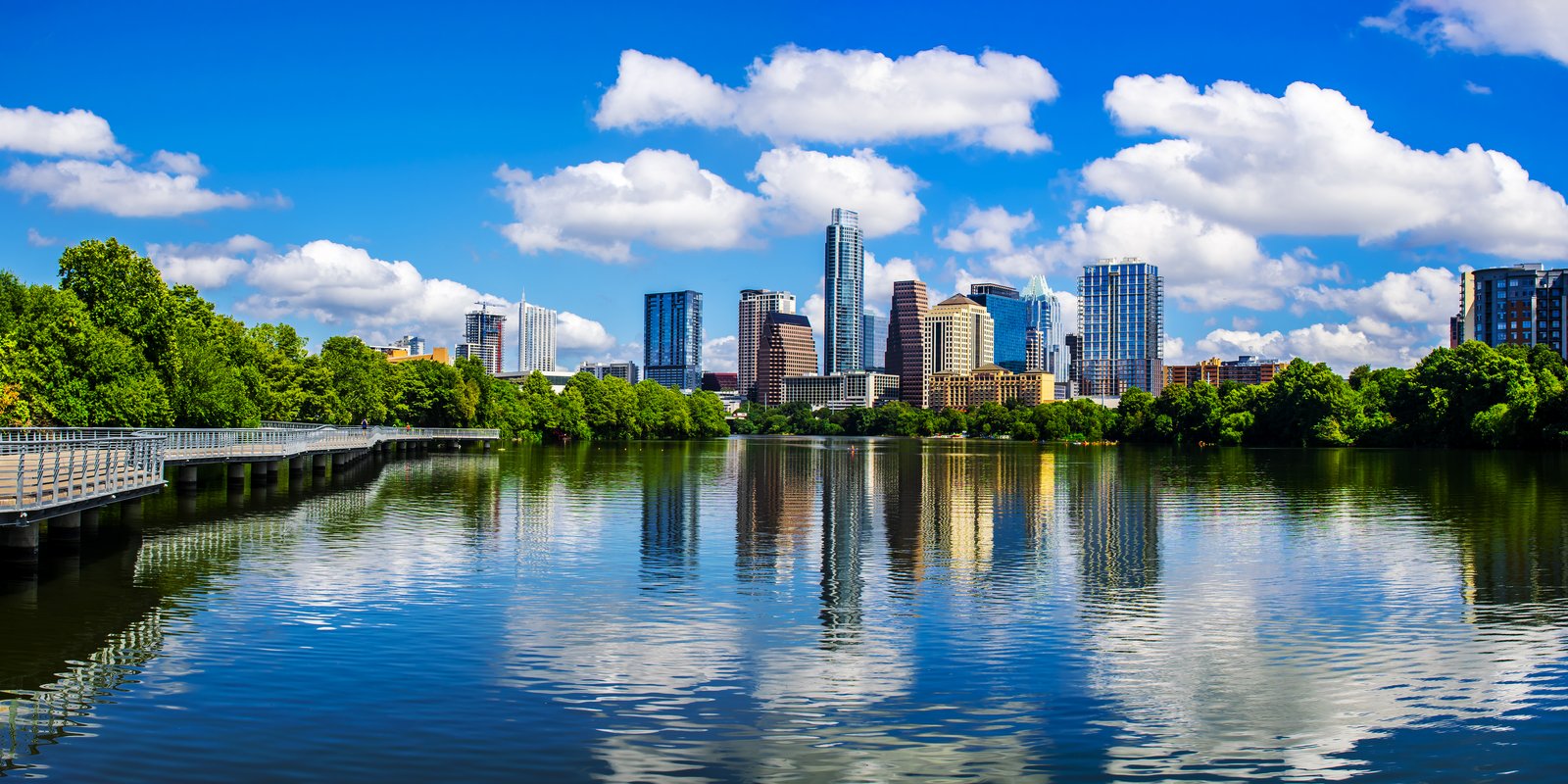 Skyline von Austin mit Hochhäusern, Bäumen und Spiegelung im Lady Bird Lake
