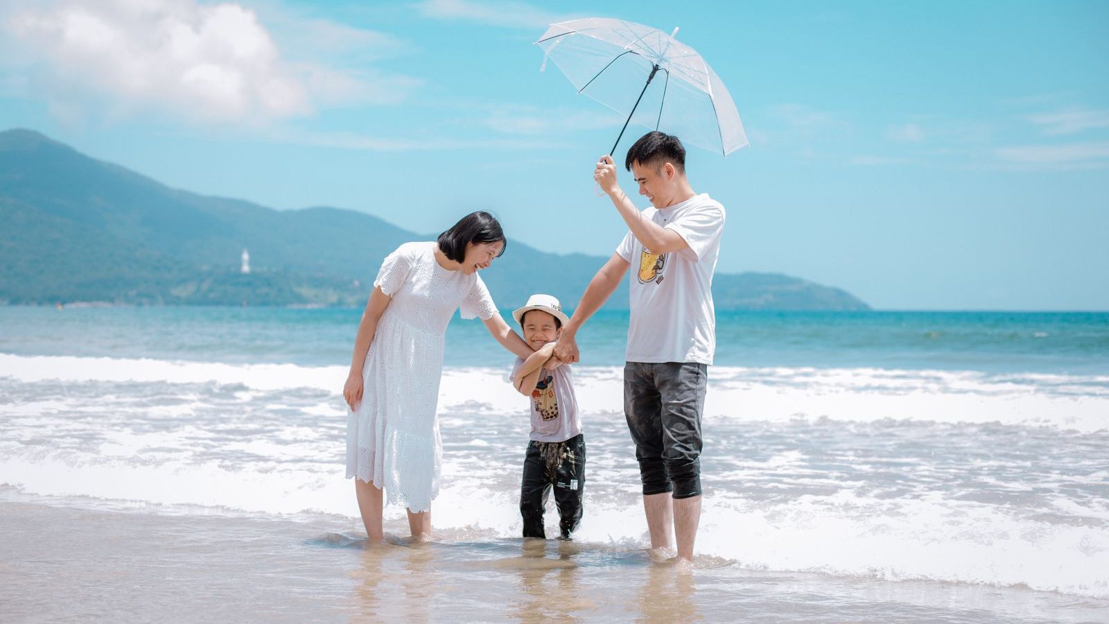 Familie am Strand unter einem Schirm